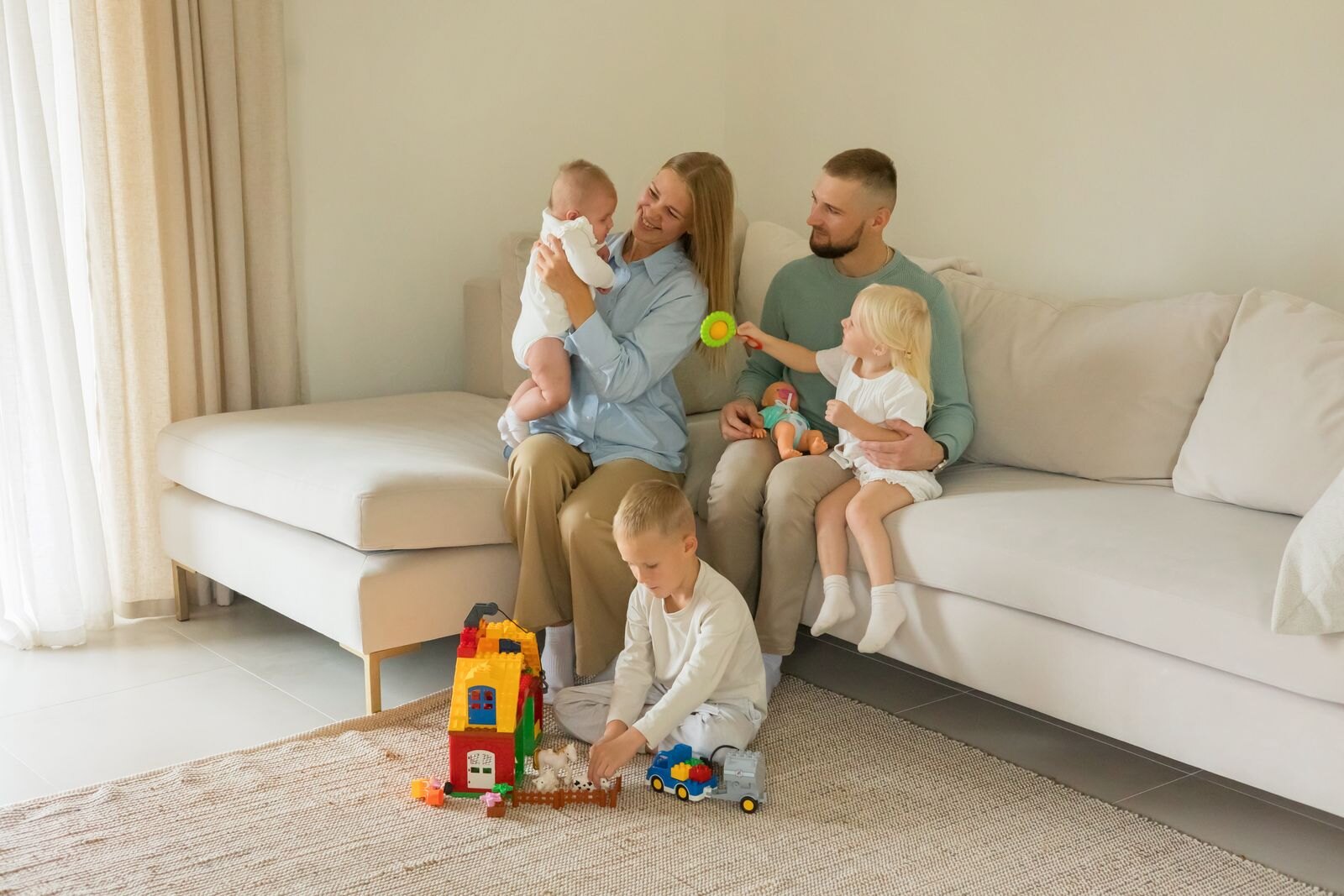 Des parents et leurs enfants jouent dans un salon clair et lumineux